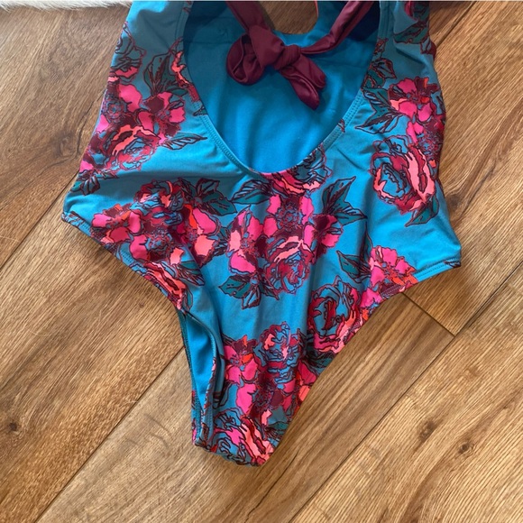 Basta Surf one-piece swimsuit with a teal background and a pink floral pattern - Picture 10 of 12